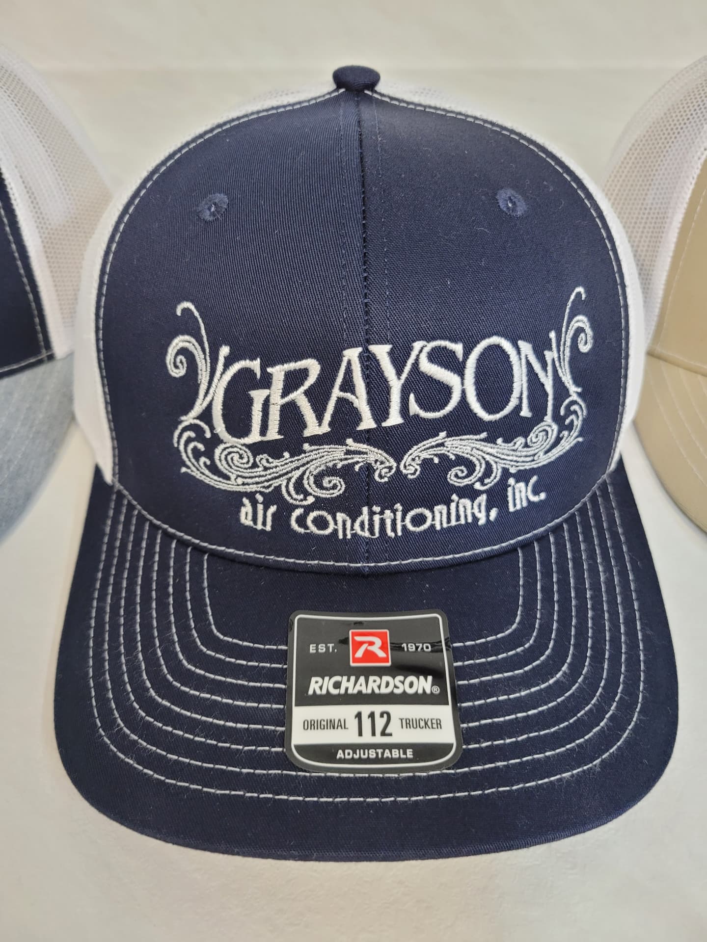 Navy and white Richardson 112 trucker hat with white embroidered Grayson Air Conditioning logo