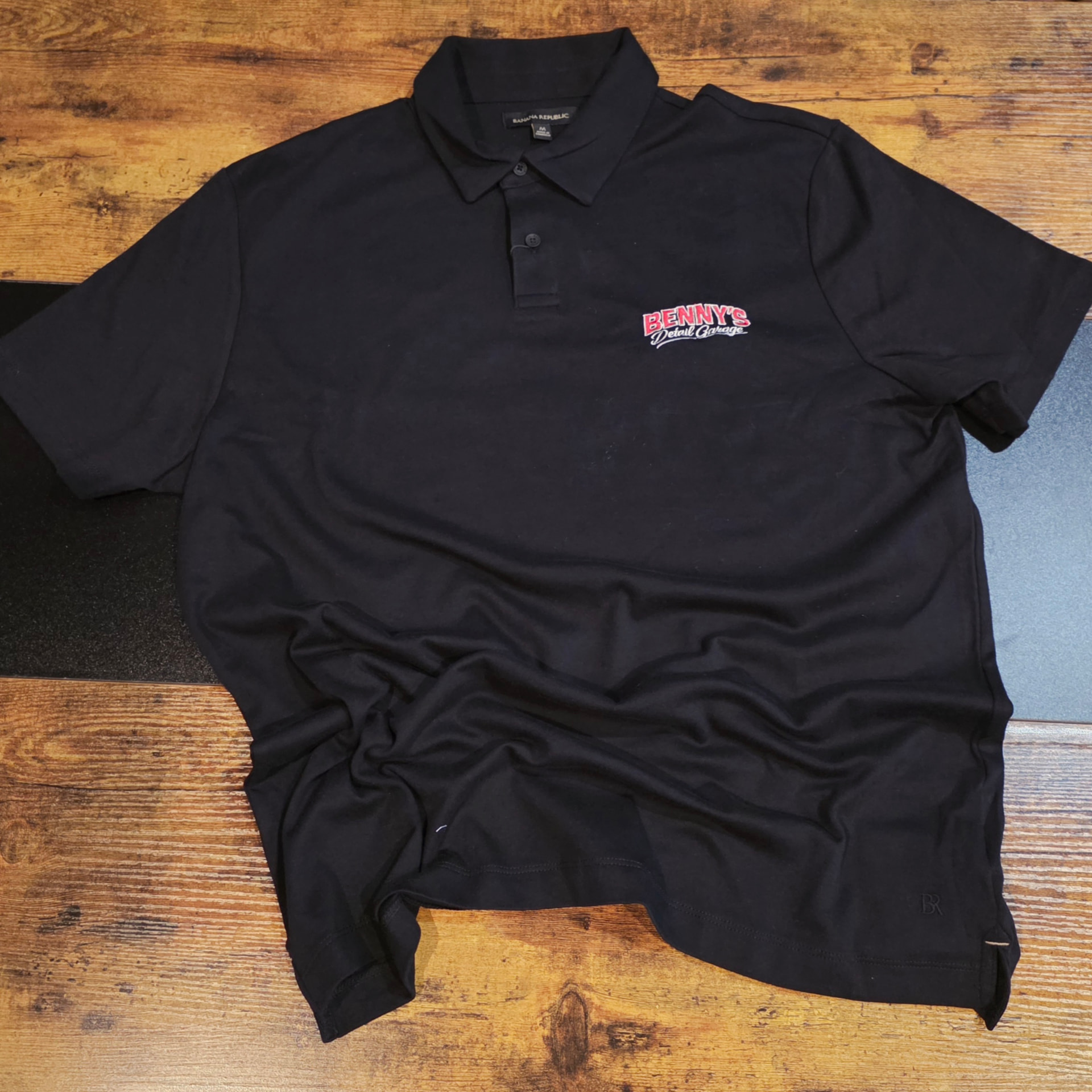 Black Banana Republic polo with red and white embroidered Benny's Detail Garage left chest logo